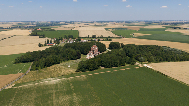 Aerial view of the Thiepval Memorial to the Missing of the Somme surrounded by lush woodland and vast agricultural fields in Thiepval Hauts de France France.