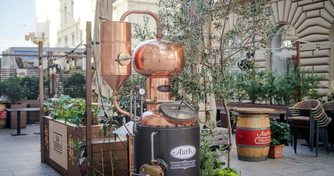 Rijeka Primorje Gorski Kotar Croatia 19 September 2026 View of a copper distillery apparatus at an outdoor cafe terrace with wooden barrels and plants. Rijeka Primorje Gorski Kotar Croatia 19 September 2026 View of a copper distillery apparatus at an outdoor cafe terrace with wooden barrels and plants.