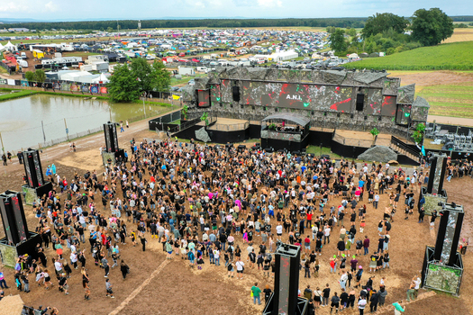 Herzogenaurach Germany 27 July 2025 Aerial view of Open Beatz Festival with a large crowd gathered in front of the main stage and a vast camping area in the background. Herzogenaurach Germany 27 July 2025 Aerial view of Open Beatz Festival with a large crowd gathered in front of the main stage and a vast camping area in the background.