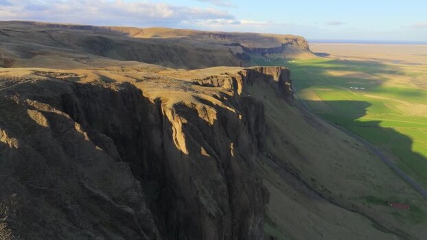 Aerial view of steep rocky cliffs and green plains Iceland. Aerial view of steep rocky cliffs and green plains Iceland.
