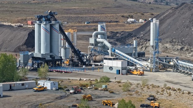 Golden United States 25 September 2026 Aerial view of an industrial concrete batch plant with tall silos conveyor belts and heavy machinery in a rural setting.