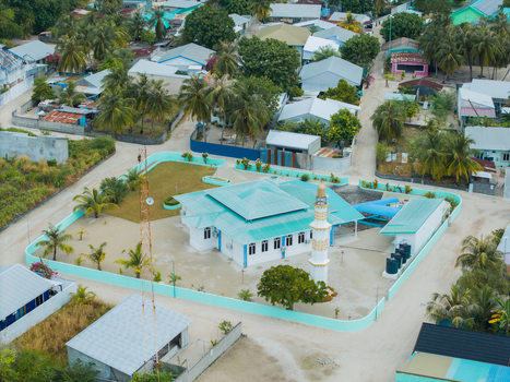 Aerial view of the island mosque with its turquoise roof and walls stands out amidst the green foliage and surrounding buildings Vashafaru Island Maldives. Aerial view of the island mosque with its turquoise roof and walls stands out amidst the green foliage and surrounding buildings Vashafaru Island Maldives.