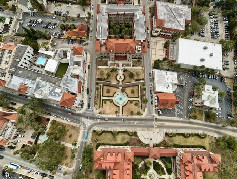 Aerial view of Flagler College featuring historic Spanish Renaissance architecture with red tiled roofs manicured gardens and urban streets St. Augustine Florida United States.