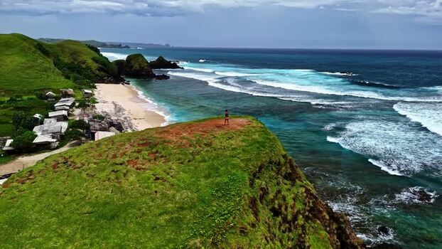 Aerial view of grassy cliff and beach in Bali Indonesia.