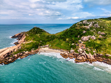Aerial view of Praia do Gravata with rocky cliffs lush green vegetation and turquoise ocean waters in Florianopolis Santa Catarina Brazil. Aerial view of Praia do Gravata with rocky cliffs lush green vegetation and turquoise ocean waters in Florianopolis Santa Catarina Brazil.