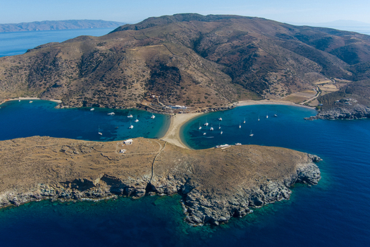 Kythnos Greece 21 September 2026 Aerial view of Kolona Beach a double sided sandy tombolo connecting the island to a rocky islet with anchored sailing boats. Kythnos Greece 21 September 2026 Aerial view of Kolona Beach a double sided sandy tombolo connecting the island to a rocky islet with anchored sailing boats.