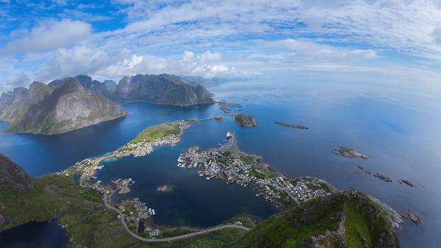Aerial view of the Lofoten islands featuring dramatic mountains coastal villages and winding roads surrounded by the deep blue sea in Vagan Municipality Nordland Norway. Aerial view of the Lofoten islands featuring dramatic mountains coastal villages and winding roads surrounded by the deep blue sea in Vagan Municipality Nordland Norway.