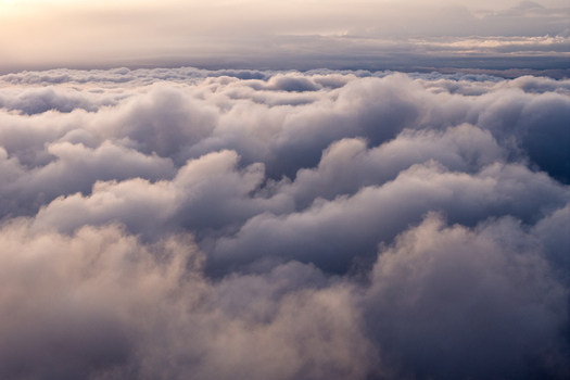 Aerial view of dense cumulus clouds with soft sunlight at sunset over Mono County California United States.