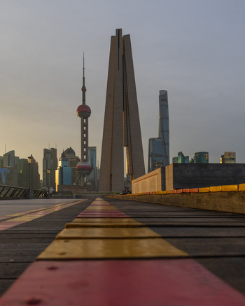 View of the Shanghai skyline featuring the Oriental Pearl Tower and the Monument to the People s Heroes from a wooden boardwalk at sunset in Shanghai Shanghai China. View of the Shanghai skyline featuring the Oriental Pearl Tower and the Monument to the People s Heroes from a wooden boardwalk at sunset in Shanghai Shanghai China.
