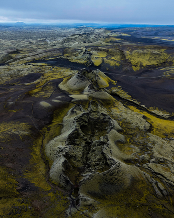 Aerial view of stark volcanic ridges cut through a landscape of moss and black rock under a brooding sky Lakagigar Iceland. Aerial view of stark volcanic ridges cut through a landscape of moss and black rock under a brooding sky Lakagigar Iceland.