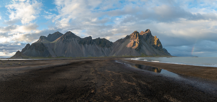 Aerial view of Vestrahorn mountain s jagged peaks meet the dark volcanic beach reflecting the sky s soft hues Höfn Iceland. Aerial view of Vestrahorn mountain s jagged peaks meet the dark volcanic beach reflecting the sky s soft hues Höfn Iceland.