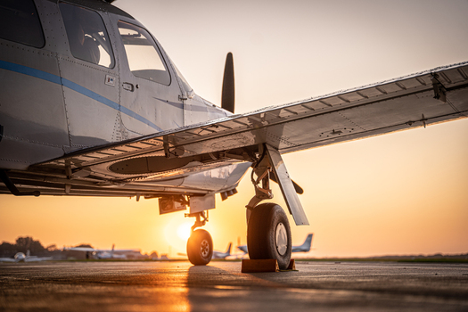 View of a light aircraft parked on the tarmac at Hannover Airport during sunset with warm golden light in Langenhagen Niedersachsen Germany. View of a light aircraft parked on the tarmac at Hannover Airport during sunset with warm golden light in Langenhagen Niedersachsen Germany.