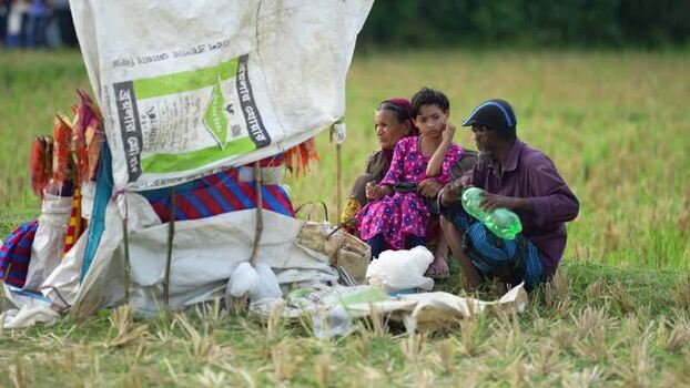View of people sitting by a makeshift stall in a field Bangladesh. View of people sitting by a makeshift stall in a field Bangladesh.