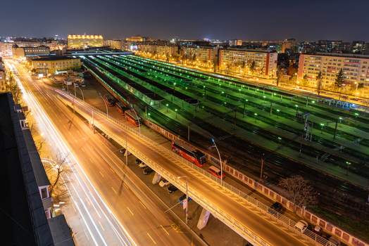 View of the Gara de Nord railway station at night with long exposure light trails from traffic on the adjacent road and illuminated train tracks in Bucharest Bucharest Romania. View of the Gara de Nord railway station at night with long exposure light trails from traffic on the adjacent road and illuminated train tracks in Bucharest Bucharest Romania.
