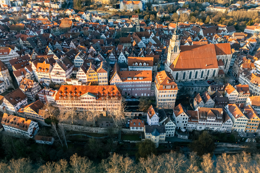Aerial view of the historic Stiftskirche and traditional half timbered houses in the old town during golden hour in Tubingen Baden Wurttemberg Germany.