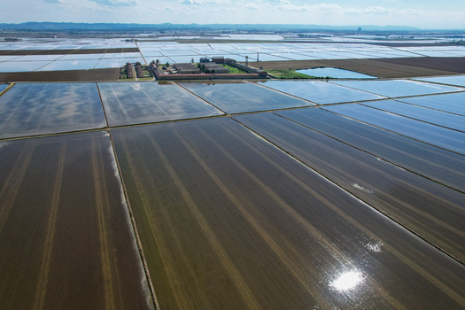 Aerial view of Azienda Agricola Veneria surrounded by flooded rice fields reflecting the sky in Veneria Piemonte Italy. Aerial view of Azienda Agricola Veneria surrounded by flooded rice fields reflecting the sky in Veneria Piemonte Italy.