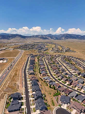 Aerial view of the Leyden residential neighborhood featuring suburban houses winding streets and a dry landscape with mountains in the background in Jefferson County Colorado United States. Aerial view of the Leyden residential neighborhood featuring suburban houses winding streets and a dry landscape with mountains in the background in Jefferson County Colorado United States.
