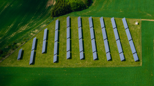 Aerial view of rows of solar panels at the Zipotin photovoltaic farm surrounded by lush green fields in Gruna Pardubicky kraj Czechia. Aerial view of rows of solar panels at the Zipotin photovoltaic farm surrounded by lush green fields in Gruna Pardubicky kraj Czechia.