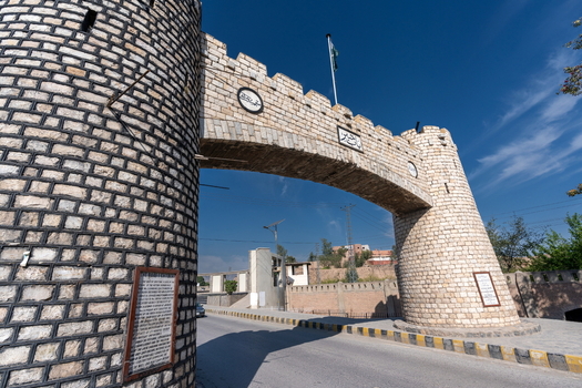 View of the historic stone archway of the Khyber Pass with its defensive towers under a clear blue sky in Khyber District Khyber Pakhtunkhwa Pakistan.