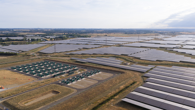 Aerial view of a vast solar farm with rows of photovoltaic panels and an electrical substation in the countryside near London England United Kingdom.