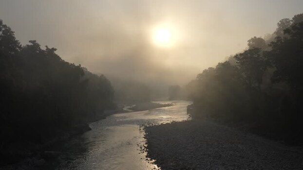 View of a river flowing through a misty valley at sunrise Nepal.
