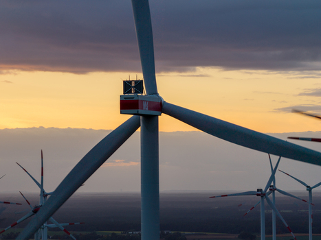 Aerial view of Sieversdorf Windpark featuring wind turbines silhouetted against a golden sunset sky in Jacobsdorf Brandenburg Germany. Aerial view of Sieversdorf Windpark featuring wind turbines silhouetted against a golden sunset sky in Jacobsdorf Brandenburg Germany.