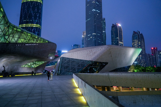 Guangzhou Guangdong Province China 24 February 2024 View of Guangzhou Opera House with its futuristic architecture illuminated at night surrounded by modern skyscrapers. Guangzhou Guangdong Province China 24 February 2024 View of Guangzhou Opera House with its futuristic architecture illuminated at night surrounded by modern skyscrapers.