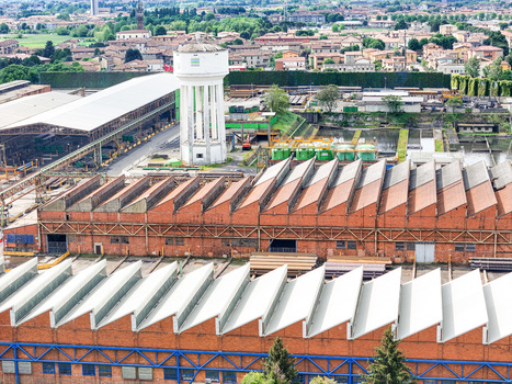 Aerial view of the industrial complex with its iconic white water tower and sawtooth factory roofs in Dalmine Lombardy Italy. Aerial view of the industrial complex with its iconic white water tower and sawtooth factory roofs in Dalmine Lombardy Italy.
