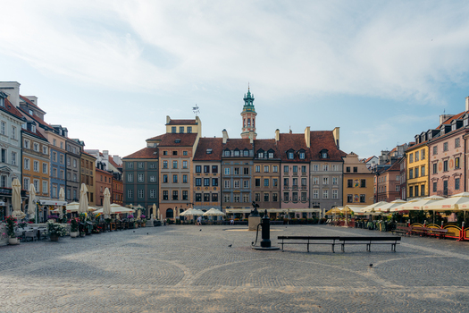 View of Warsaw Old Town market square with colorful historic buildings cobblestone ground cafe umbrellas and a central fountain in Warsaw Masovian Voivodeship Poland. View of Warsaw Old Town market square with colorful historic buildings cobblestone ground cafe umbrellas and a central fountain in Warsaw Masovian Voivodeship Poland.