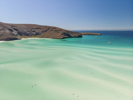 Aerial view of Balandra beach featuring turquoise shallow waters intricate sandbars and surrounding arid hills in La Paz Baja California Sur Mexico. Aerial view of Balandra beach featuring turquoise shallow waters intricate sandbars and surrounding arid hills in La Paz Baja California Sur Mexico.