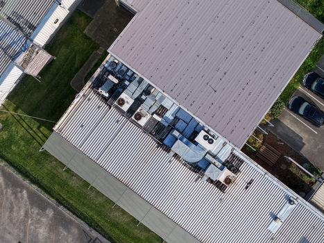 Melbourne VIC Australia 22 September 2026 Aerial view of industrial factory rooftops in Kilsyth featuring corrugated metal surfaces HVAC units and adjacent parking areas. Melbourne VIC Australia 22 September 2026 Aerial view of industrial factory rooftops in Kilsyth featuring corrugated metal surfaces HVAC units and adjacent parking areas.