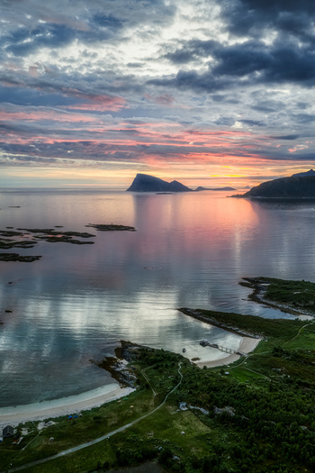 Aerial view of the coastal landscape of Sommaroy with sandy beaches rocky shores and calm water reflecting the dramatic sunset sky in Sommaroy Troms Norway. Aerial view of the coastal landscape of Sommaroy with sandy beaches rocky shores and calm water reflecting the dramatic sunset sky in Sommaroy Troms Norway.