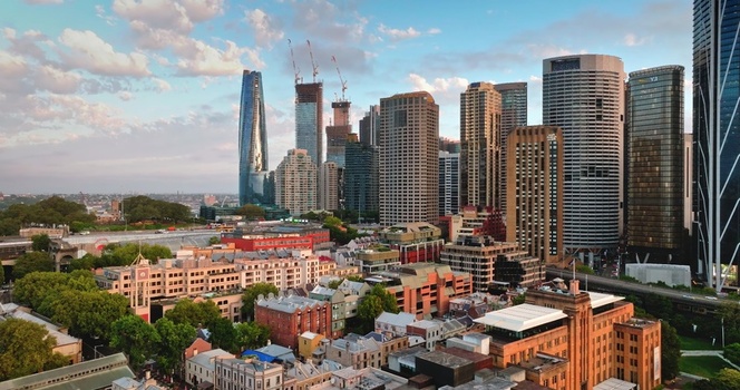 Aerial view of the Sydney CBD skyline featuring modern skyscrapers and historic buildings under a soft golden hour light in Sydney New South Wales Australia. Aerial view of the Sydney CBD skyline featuring modern skyscrapers and historic buildings under a soft golden hour light in Sydney New South Wales Australia.