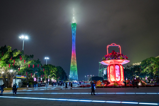 Guangzhou Guangdong Province China 24 February 2024 View of the illuminated Canton Tower at night with festive decorations and people walking in the square. Guangzhou Guangdong Province China 24 February 2024 View of the illuminated Canton Tower at night with festive decorations and people walking in the square.
