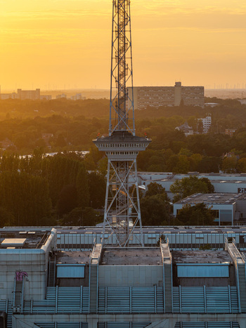 Aerial view of the ICC Berlin featuring its iconic radio tower and brutalist architecture during a warm golden hour sunset in Berlin Berlin Germany. Aerial view of the ICC Berlin featuring its iconic radio tower and brutalist architecture during a warm golden hour sunset in Berlin Berlin Germany.