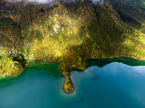 Aerial view of Lagoa do Fogo crater lake with steep volcanic slopes covered in lush greenery and turquoise water in Agua de Alto Azores Portugal. Aerial view of Lagoa do Fogo crater lake with steep volcanic slopes covered in lush greenery and turquoise water in Agua de Alto Azores Portugal.