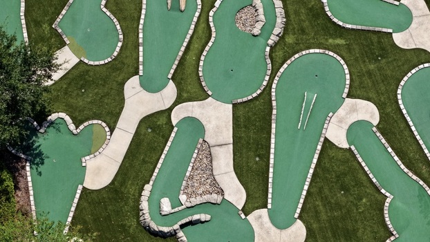 Aerial view of the miniature golf course at Windward Ranch Boulevard with green artificial turf concrete pathways and stone obstacles in St. Johns County Florida United States. Aerial view of the miniature golf course at Windward Ranch Boulevard with green artificial turf concrete pathways and stone obstacles in St. Johns County Florida United States.