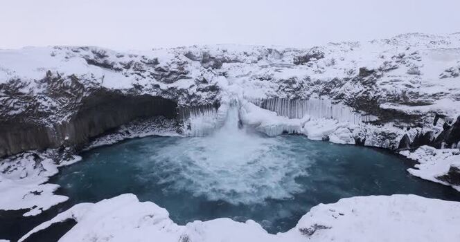View of frozen waterfall in winter landscape Iceland.