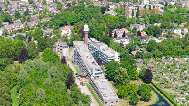 Aerial view of the KNMI building complex and its iconic radar tower surrounded by lush green trees and residential neighborhoods in De Bilt Utrecht Netherlands. Aerial view of the KNMI building complex and its iconic radar tower surrounded by lush green trees and residential neighborhoods in De Bilt Utrecht Netherlands.