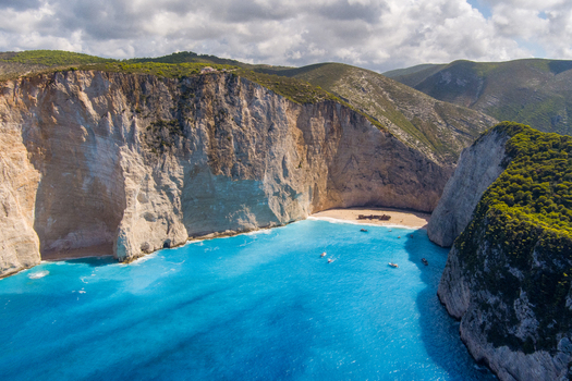 Aerial view of Navagio beach with its iconic shipwreck turquoise waters and towering limestone cliffs on the coast of Zakynthos Navagio Greece.