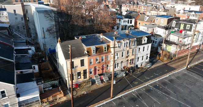 Aerial view of a row of residential houses with rooftops and a parking lot in the urban neighborhood of Allentown Pennsylvania United States.