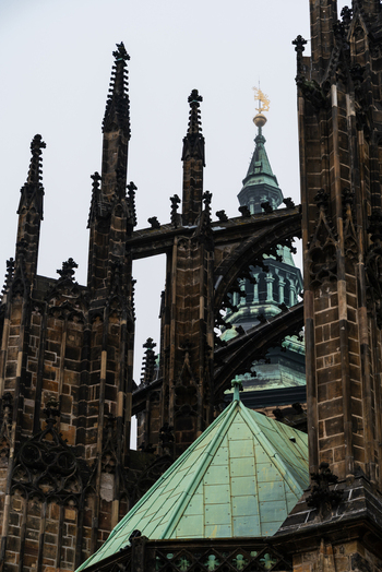 View of the intricate Gothic spires flying buttresses and copper green roof of St. Vitus Cathedral Prague Prague Czechia.
