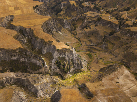 Aerial view of Toachi River Canyon featuring dramatic rugged cliffs winding river and golden agricultural fields in Zumbahua Cotopaxi Ecuador. Aerial view of Toachi River Canyon featuring dramatic rugged cliffs winding river and golden agricultural fields in Zumbahua Cotopaxi Ecuador.