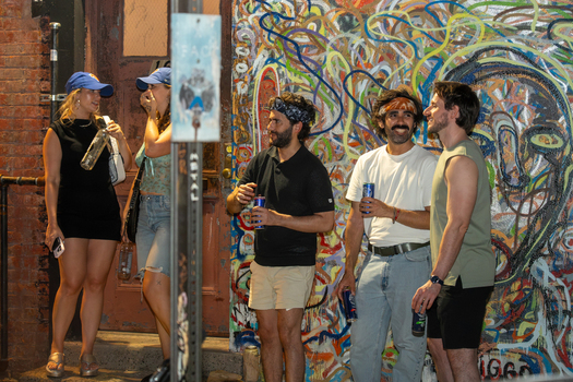 Williamsburg Brooklyn New York USA 14 June 2026 View of people celebrating in front of a colorful graffiti wall. Williamsburg Brooklyn New York USA 14 June 2026 View of people celebrating in front of a colorful graffiti wall.