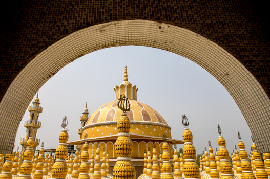 View of a golden dome and minarets rise majestically against the sky framed by the intricate archway in Tangail Dhaka Division Bangladesh. View of a golden dome and minarets rise majestically against the sky framed by the intricate archway in Tangail Dhaka Division Bangladesh.