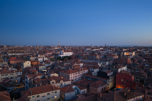 Aerial view of the historic city of Venice with its dense collection of terracotta rooftops narrow canals and ancient architecture illuminated during the blue hour in Venice Veneto Italy. Aerial view of the historic city of Venice with its dense collection of terracotta rooftops narrow canals and ancient architecture illuminated during the blue hour in Venice Veneto Italy.