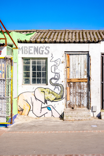 View of a spaza shop with a colorful elephant mural on a white wall under a clear blue sky Cape Town Western Cape South Africa. View of a spaza shop with a colorful elephant mural on a white wall under a clear blue sky Cape Town Western Cape South Africa.
