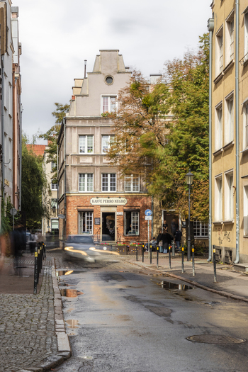 Gdansk Poland 05 September 2026 View of a charming street in the historic center of Gdansk featuring a cafe with a brick facade cobblestone pavement and autumn trees under a cloudy sky. Gdansk Poland 05 September 2026 View of a charming street in the historic center of Gdansk featuring a cafe with a brick facade cobblestone pavement and autumn trees under a cloudy sky.
