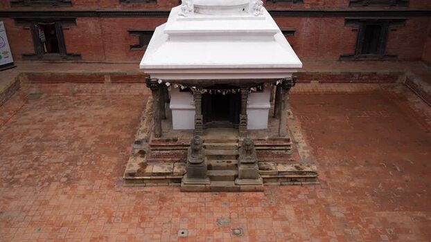 View of a white shrine in a brick courtyard Nepal.