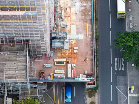 Aerial view of Steglitzer Kreisel construction site with scaffolding building materials and equipment next to a busy road with a bus and a van in Berlin Berlin Germany. Aerial view of Steglitzer Kreisel construction site with scaffolding building materials and equipment next to a busy road with a bus and a van in Berlin Berlin Germany.